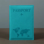 Signature Leather Passport Cover in turquoise Blue standing on a wooden tabletop with its map design visible.