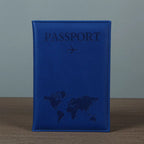 Signature Leather Passport Cover in Deep Blue standing on a wooden tabletop with its stitched border visible.