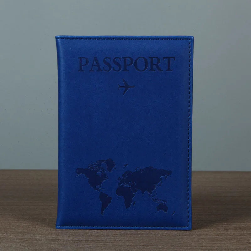Signature Leather Passport Cover in Deep Blue standing on a wooden tabletop with its stitched border visible.