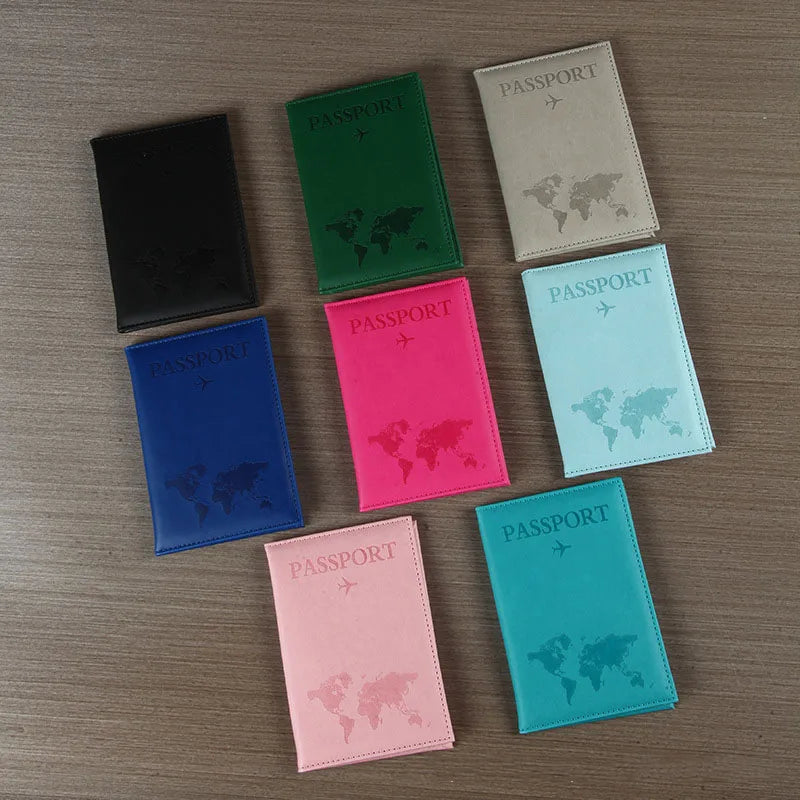 Signature Leather Passport Cover in all eight imported colors arranged face-up on a wood surface.