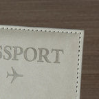 Signature Leather Passport Cover close-up of Gray PU leather texture, passport lettering and edge stitching.