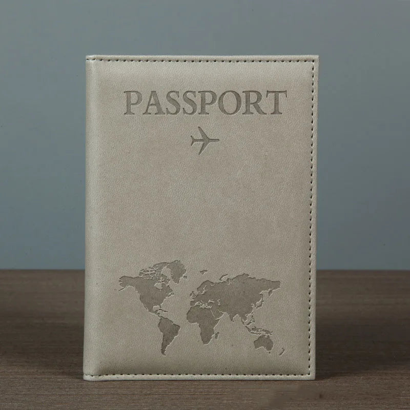 Signature Leather Passport Cover in Gray standing on a wooden tabletop with its complete front visible.