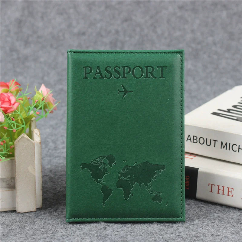 Signature Leather Passport Cover in Green, standing upright with the airplane symbol and world map on its front.