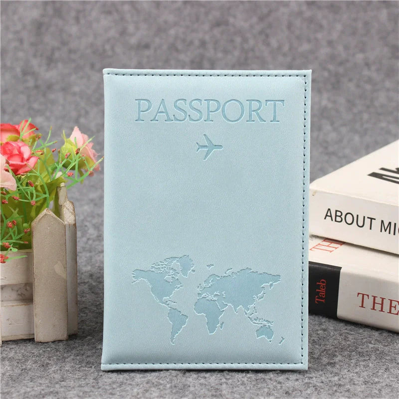 Signature Leather Passport Cover in Light Blue, shown upright beside flowers with its pale aqua finish.