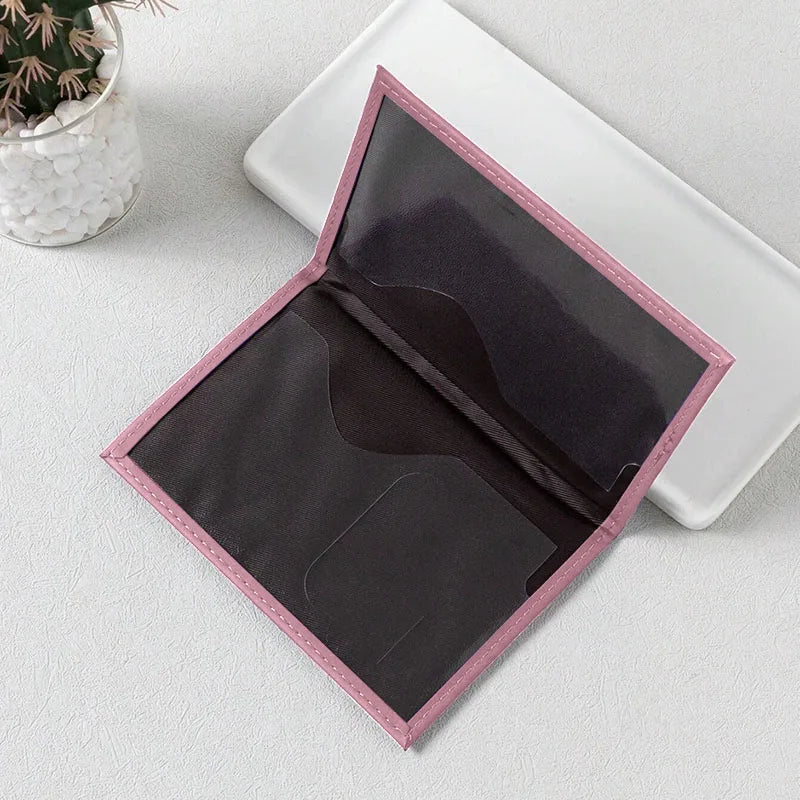 Signature Leather Passport Cover opened to show the dark interior document pockets and pink stitched border.