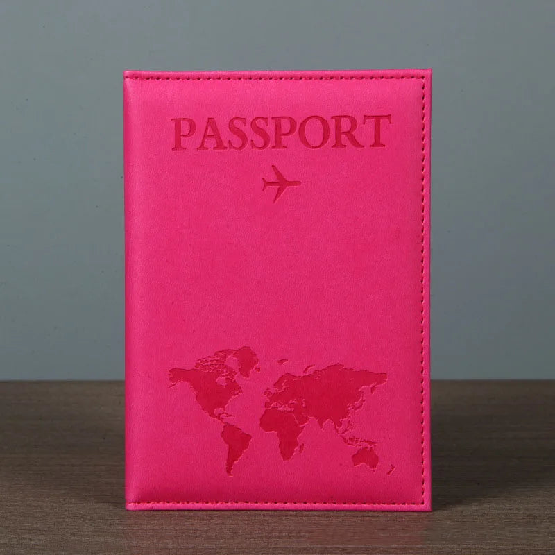 Signature Leather Passport Cover in Rose Red standing on a wooden tabletop with its hot pink front visible.