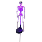 Purple-lit skeleton solar yard stake with its black solar panel on a white background