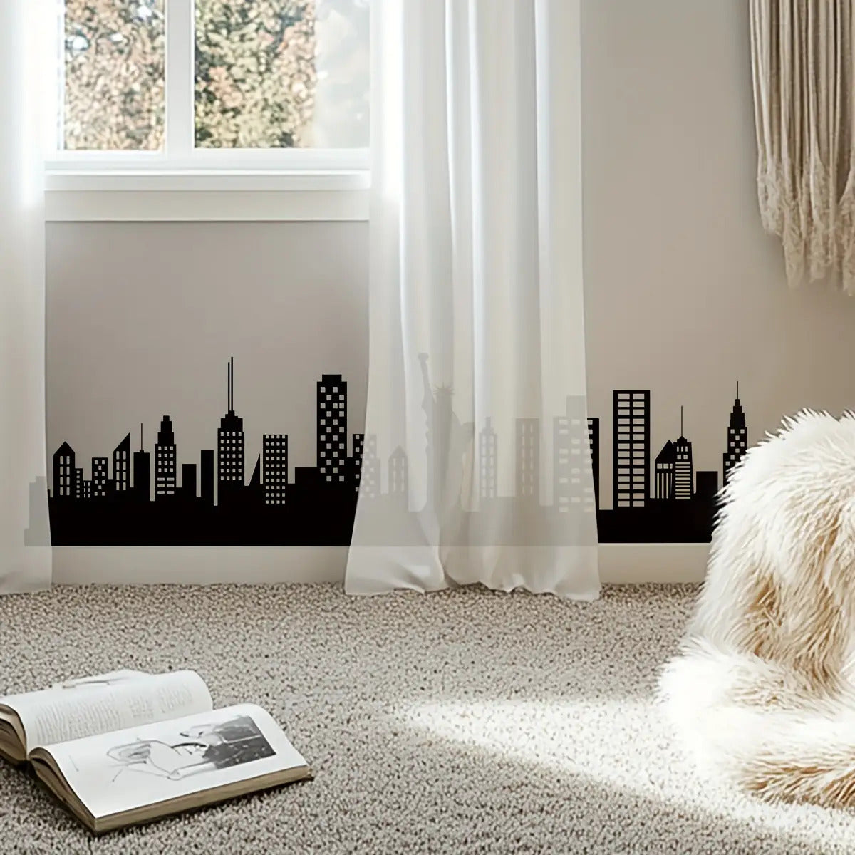 Skyline Wall Decal applied along a bedroom baseboard behind sheer curtains in a bright reading corner