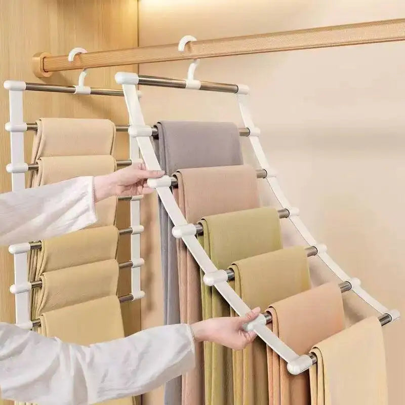 Space Saving Pants Hanger holding folded trousers while a person tilts the front rack outward in a wooden closet.