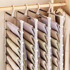 Space Saving Pants Hanger arranged in a row of four racks holding neutral-colored trousers beside a white jacket.