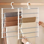 Space Saving Pants Hanger with beige trousers being arranged on the bars beside a second loaded hanger.