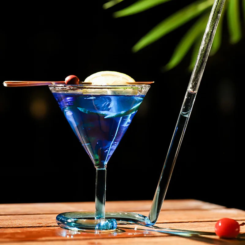 Spiral Straw Cocktail Glass with a blue drink, lemon and cherry garnish on a wooden table