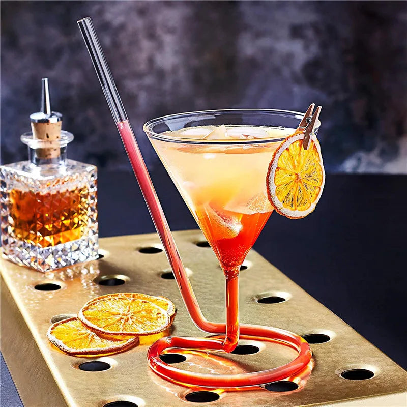 Spiral Straw Cocktail Glass filled with a layered orange drink beside dried citrus slices