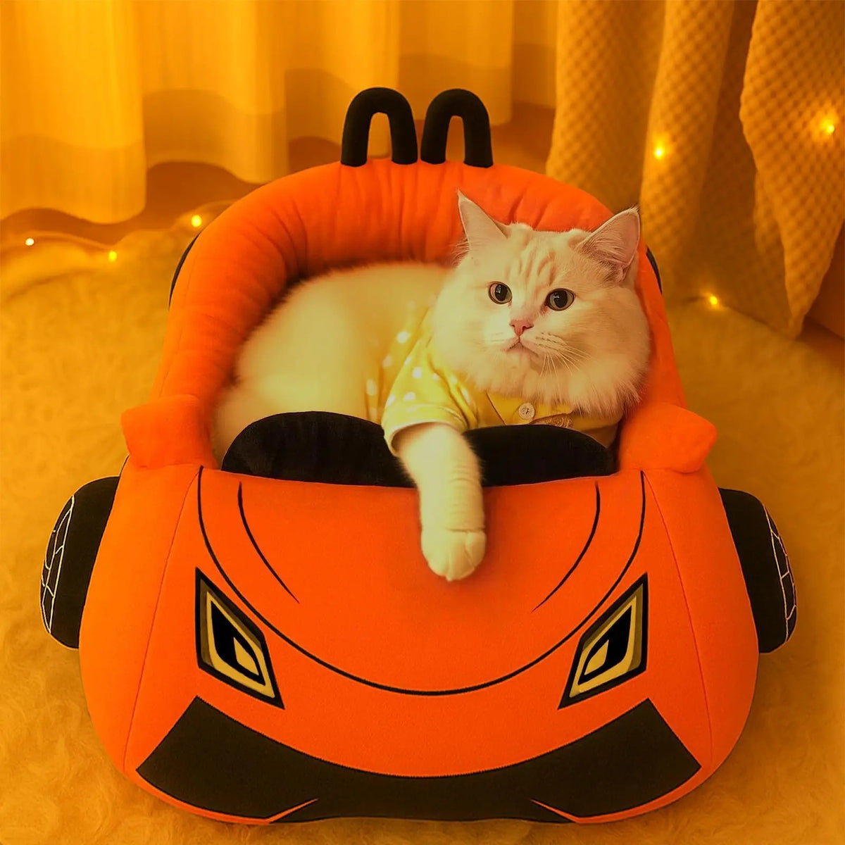 Sports Car Cat Bed with a white cat in a yellow shirt, shown from the front in warm lighting