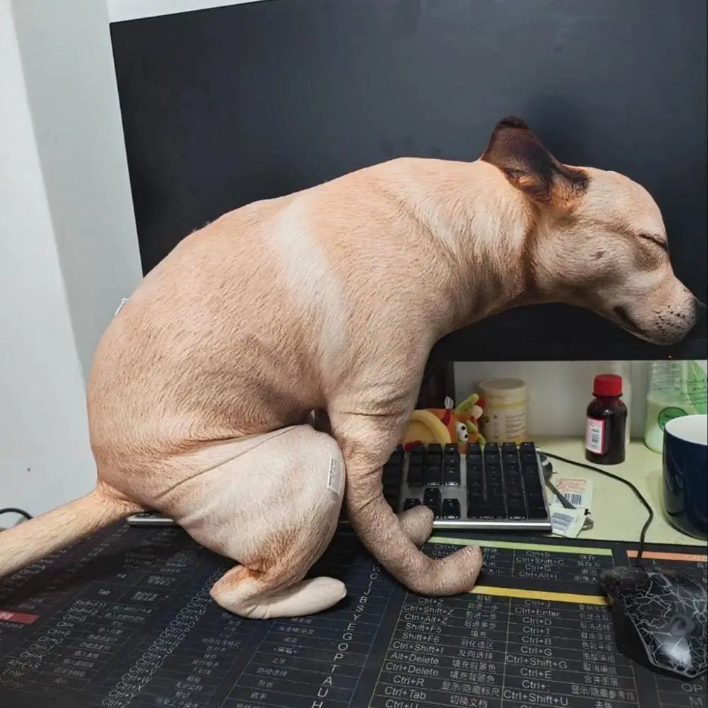 Squatting Dog Plush Toy tan dog posed beside a keyboard and monitor on an office desk.