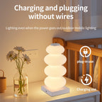 Stacked Pebble RGB Lamp glowing warm white beside flowers with charging-use graphics.