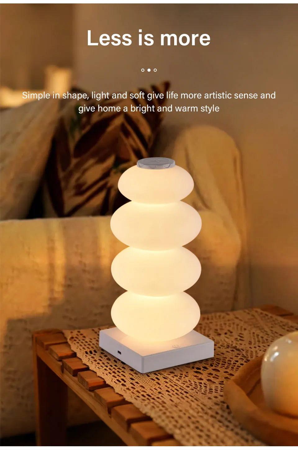 Stacked Pebble RGB Lamp glowing warm white on a wooden table with a woven runner.