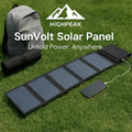 HighPeak SunVolt Solar Panel unfolded on grass charging a phone with a backpack and thermos nearby outdoors