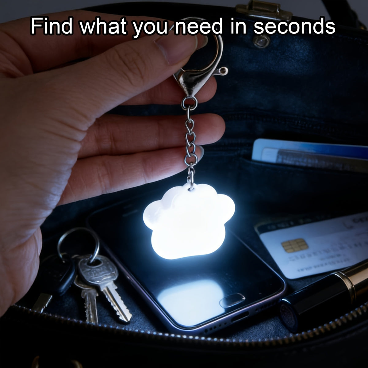 Touch Activated Bag Light — Paw shape held over keys and a phone inside a dark handbag.