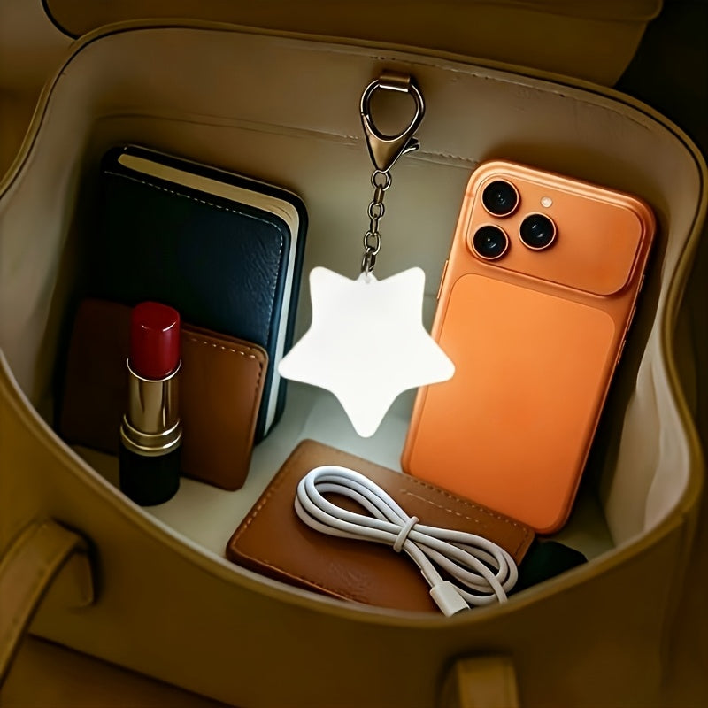 Touch Activated Bag Light — Star shape lighting a handbag beside an orange phone and charging cable.