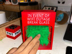 Touch Grass Meme Box on a desktop with a hand touching the green grass through the front opening