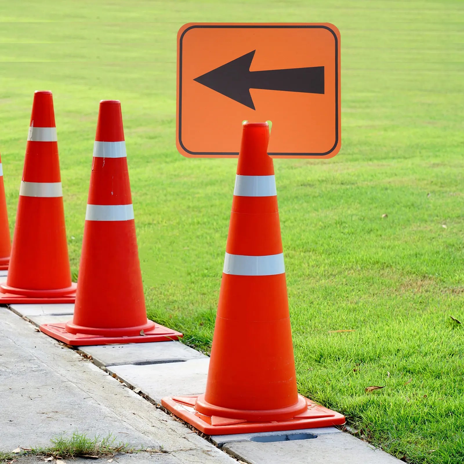 Traffic Cone Arrow Sign mounted outdoors with multiple cones marking a directional route beside grass