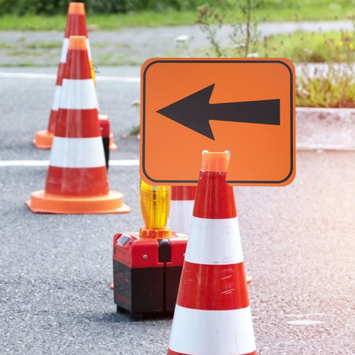 Traffic Cone Arrow Sign pointing left from a cone within a temporary roadwork setup with warning beacon