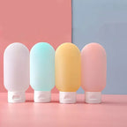 Travel Squeeze Bottle Set four bottles in white, pale blue, yellow, and pink standing on their white flip caps.
