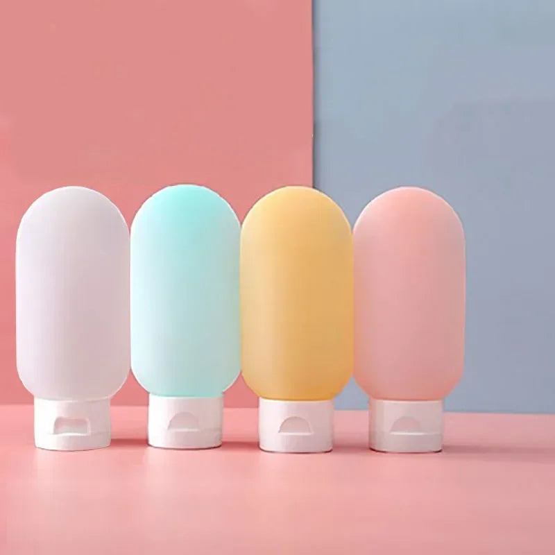 Travel Squeeze Bottle Set four bottles in white, pale blue, yellow, and pink standing on their white flip caps.
