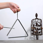 Triangle Instrument Set held for practice beside a decorative lantern, showing the suspension handle