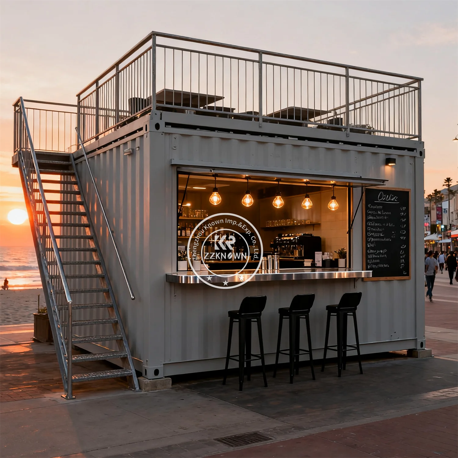 Two-Story Container Restaurant in gray with rooftop seating and a service window beside a beach at sunset