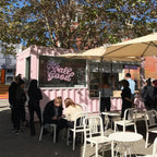 Pink container café example serving customers through a street-side service window with outdoor seating