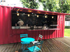 Red container restaurant example with an open service window, stainless counters, and outdoor café seating