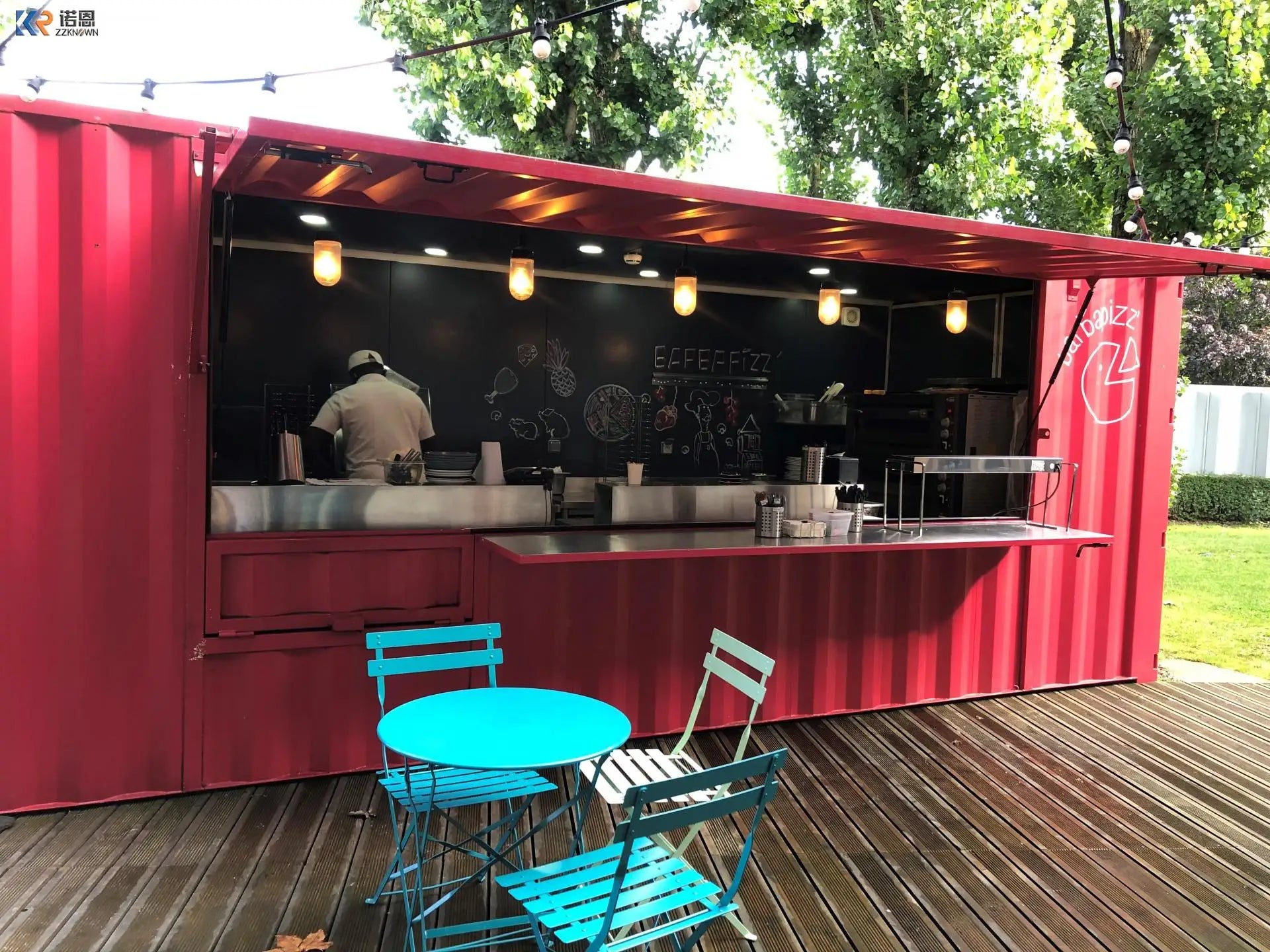 Red container restaurant example with an open service window, stainless counters, and outdoor café seating