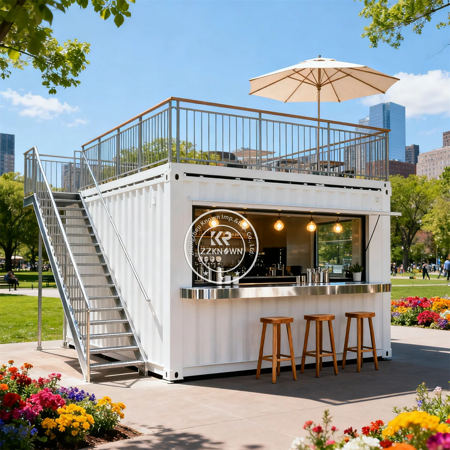 Two-Story Container Restaurant in white with exterior stairs, rooftop umbrella, and park café counter