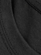 Under A Tack Tee close-up showing the texture of the black cotton knit fabric