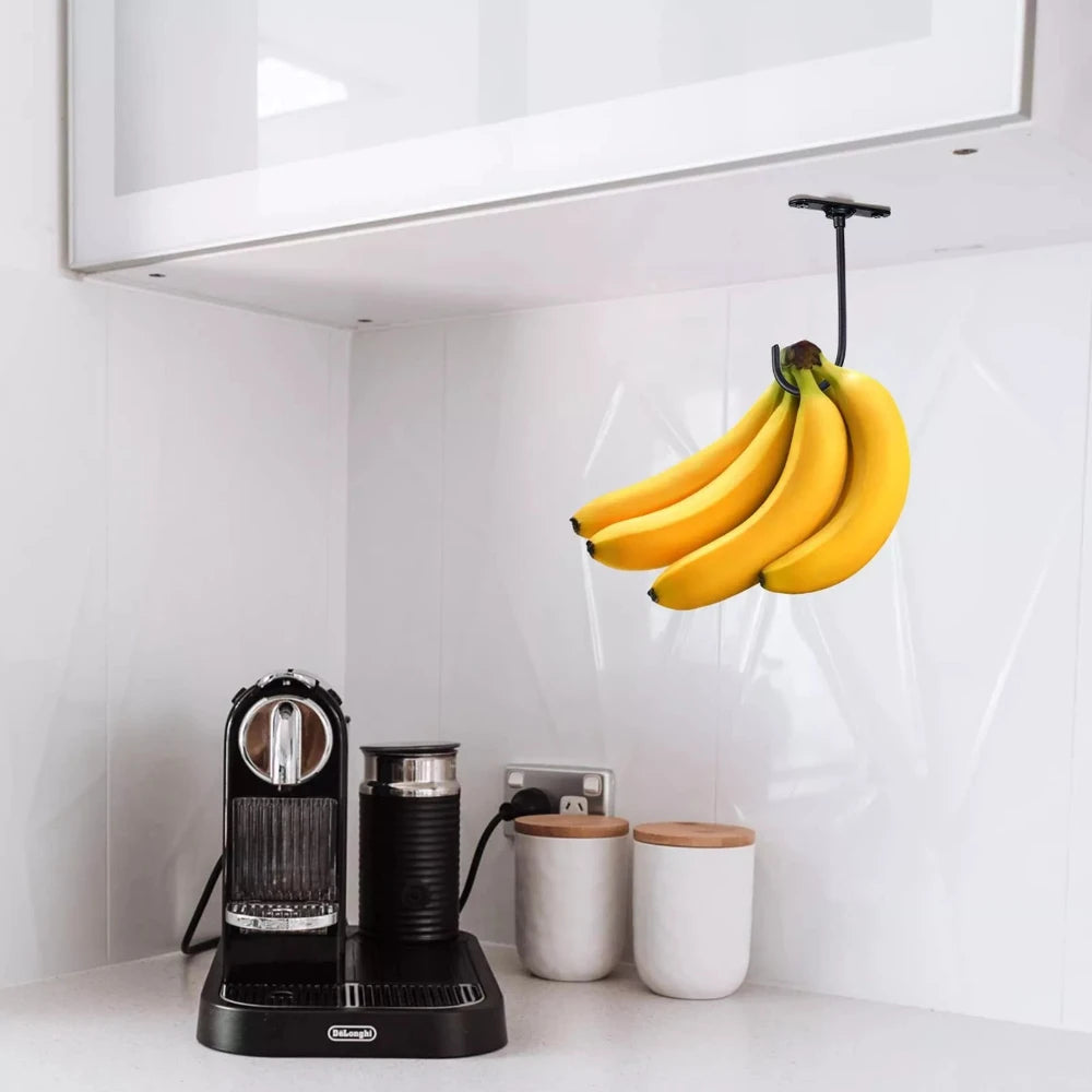 Under-Cabinet Banana Hook holding bananas above a coffee station in a bright white kitchen