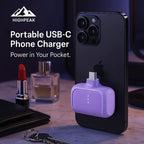 HighPeak Portable USB-C Phone Charger in purple attached to black phone on marble table with keys and lipstick nearby