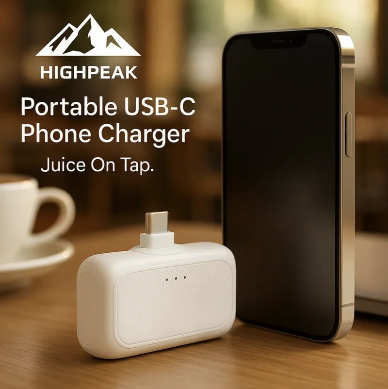 HighPeak Portable USB-C Phone Charger in white plugged into a phone on a wood table with coffee cup background