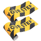 Watch Your Step Decals shown as two curled strips with textured black lettering and hazard stripes