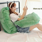 Wearable Turtle Shell Pillow in green supporting a person reading comfortably on a bed
