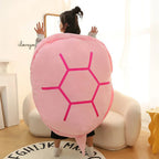Wearable Turtle Shell Pillow in pink worn from behind in a cheerful bedroom setting