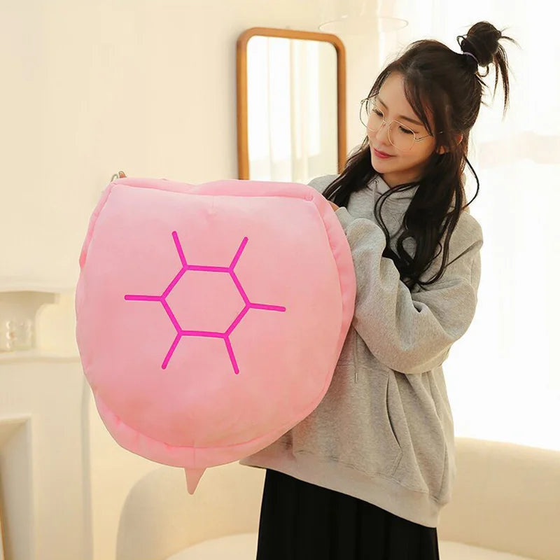 Wearable Turtle Shell Pillow in pink held by a person to demonstrate its generous scale