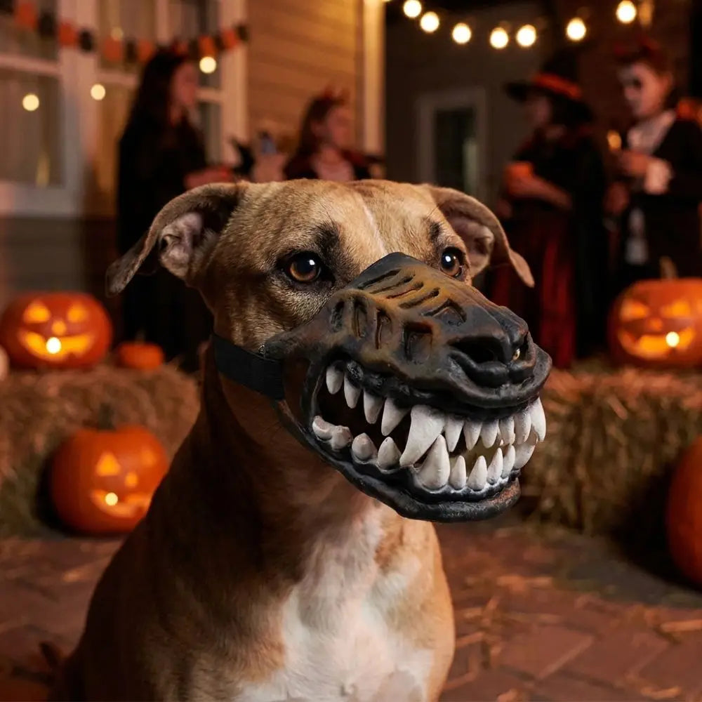 Brown and white dog in Werewolf Fangs Dog Mask without blood beside pumpkins at a nighttime Halloween display
