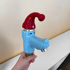 Wiggly Hat Sink Faucet held at an angle against a beige wall, showing the mounting stem and metal aerator.