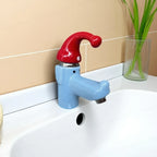 Wiggly Hat Sink Faucet installed on a white basin with the water off and a clear vase alongside.