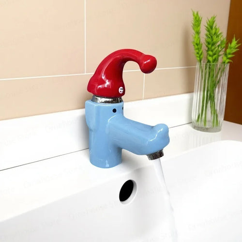 Wiggly Hat Sink Faucet running into a white basin beside a glass vase against beige tiles.