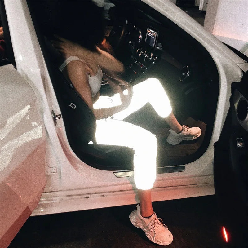 Women’s Reflective Joggers bright reflective effect while seated in a white car with one foot outside