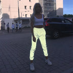Women’s Reflective Joggers catching light on a paved street with a white crop top and sneakers