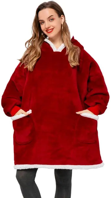 Cozy oversized hoodie blanket in deep red with sherpa lining and front pockets shown on model against white background